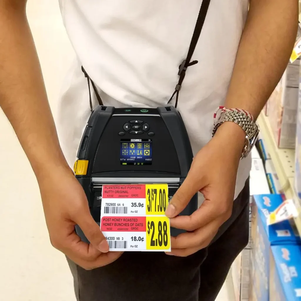 Employee printing a shelf label on a belt printer in the aisle